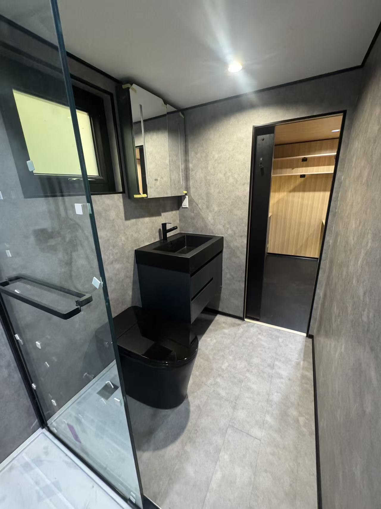 MagicSlide tiny house bathroom with marble-top walnut vanity, backlit mirror and smart toilet