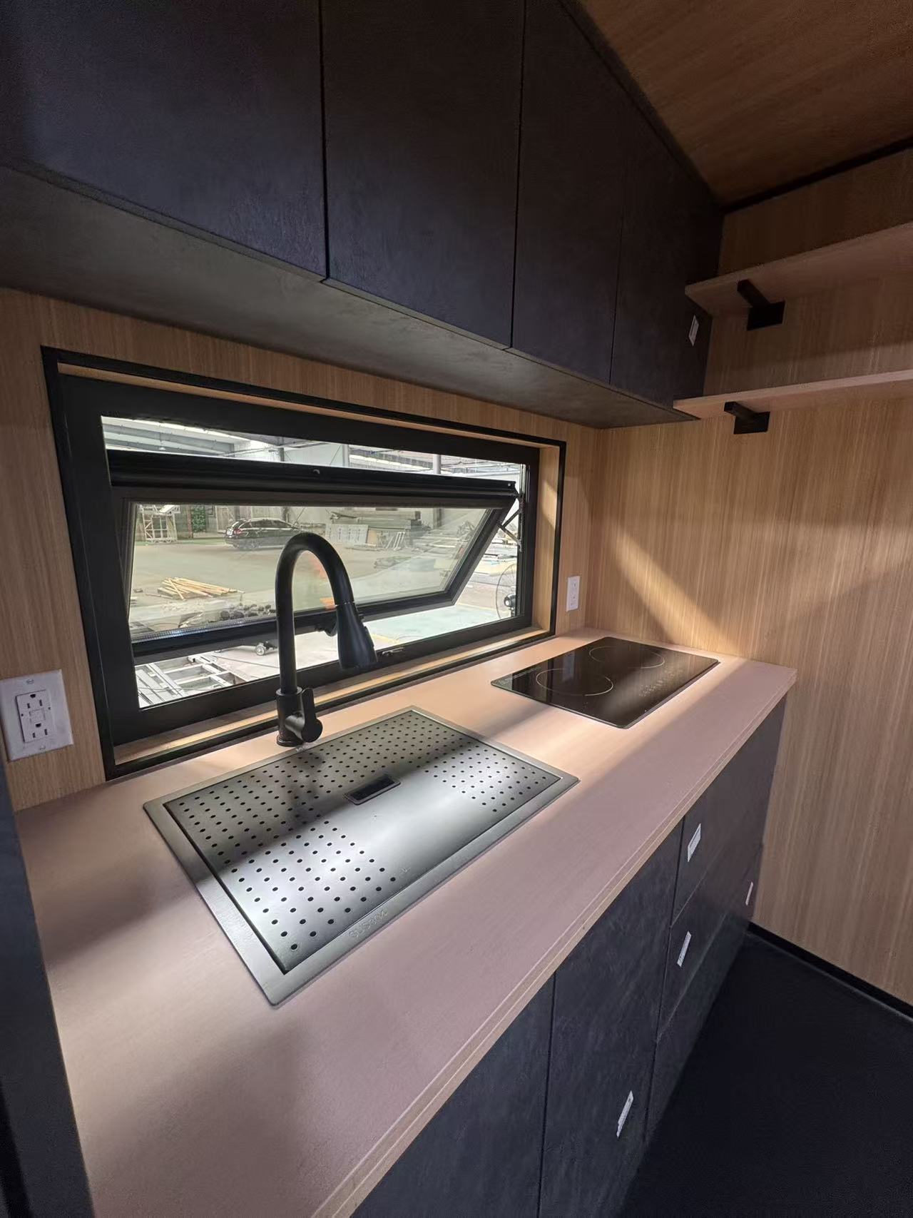 MagicSlide tiny house bathroom with walk-in glass shower, black vanity and concrete-look tile