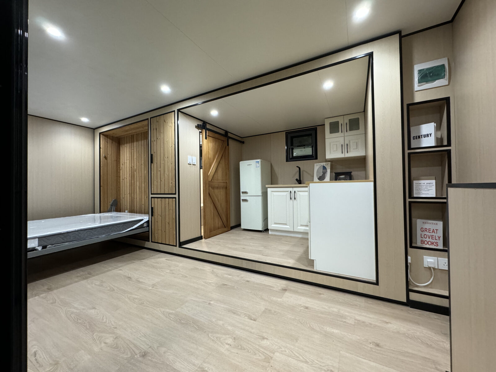 MagicSlide expandable tiny house on wheels shown expanded at the factory, matte black exterior