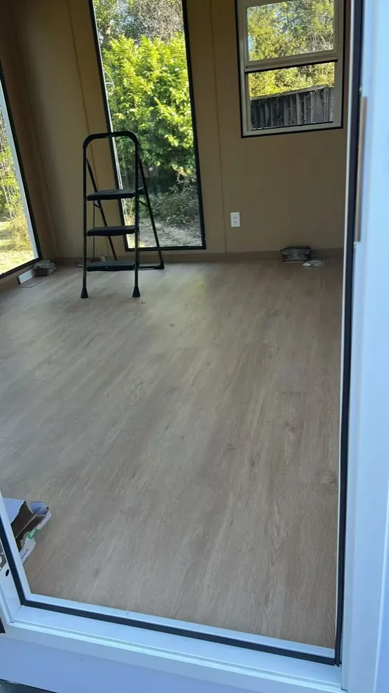 Finished MagicNest interior with vinyl plank flooring and full-height glazing